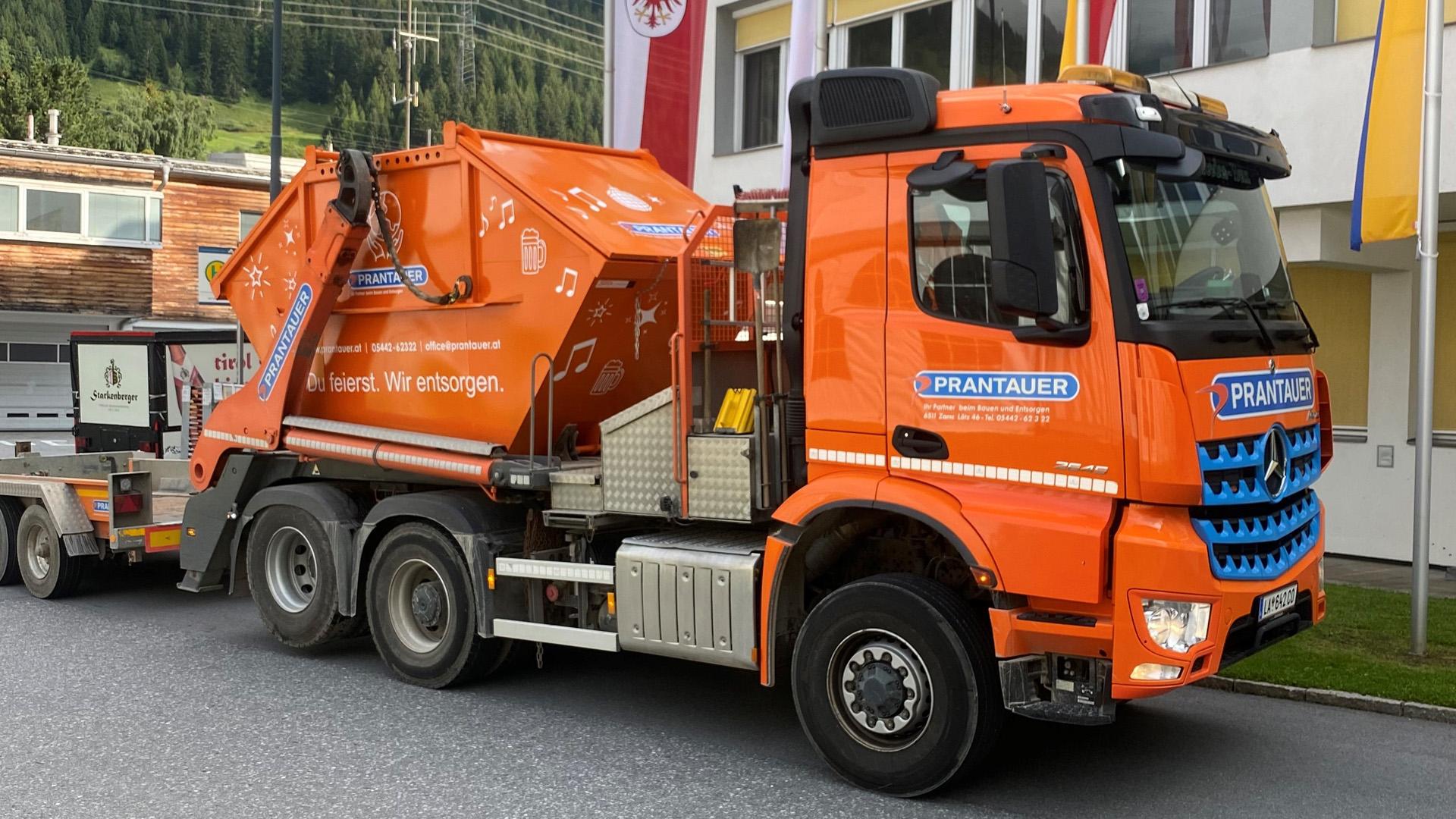 Absetzkipper mit orangen Eventcontainer beladen