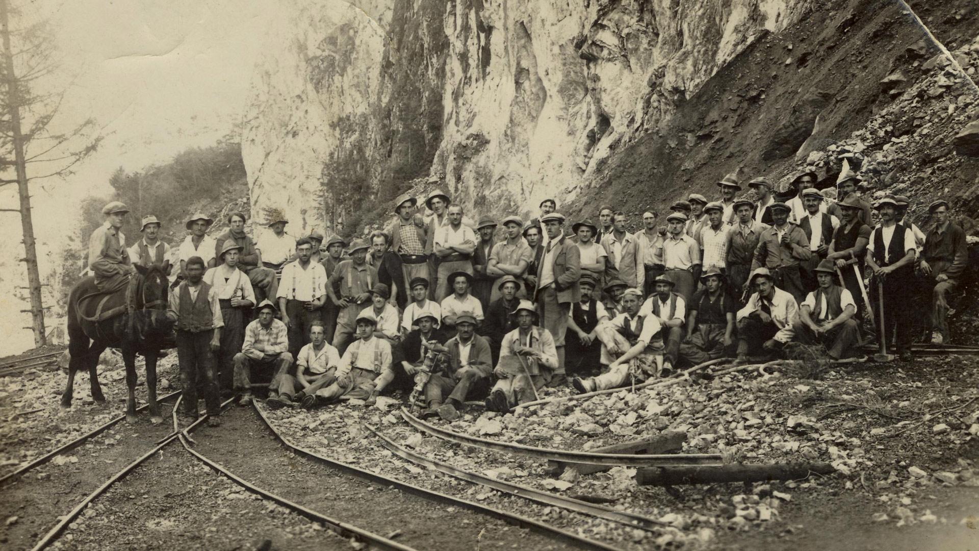 Altes Gruppenfoto der Steinbruchmitarbeiter bei den Gleisen im Steinbruch